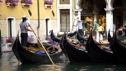 Fototapeta na wymiar Handsome gondoliers entertaining tourists, giving ride around Venice sights