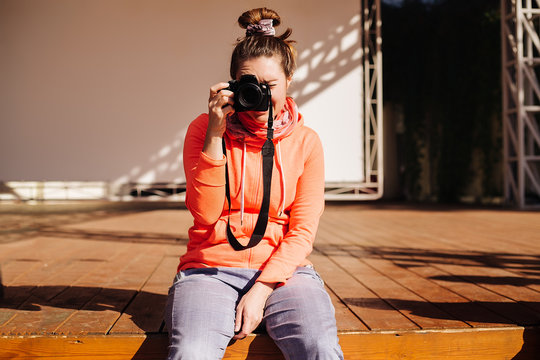 Hipster girl with a camera sitting outdoor