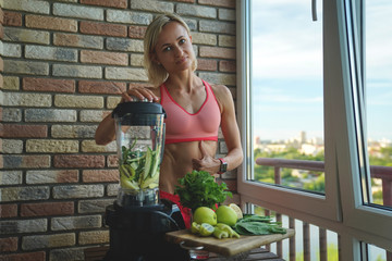 close up of young woman with blender and green vegetables making detox shake or smoothie at home
