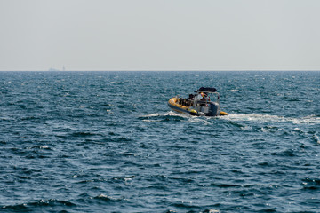 seascape with a motor boat on the horizon