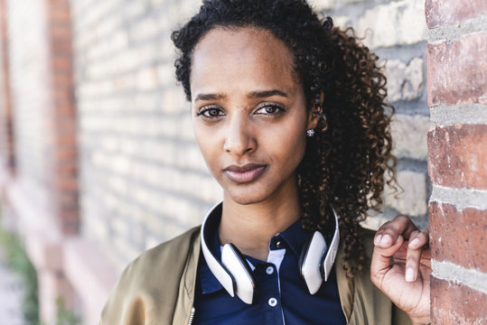 Portrait of a beautiful young woman in front of brick wall