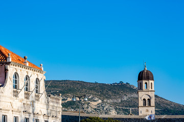 Fototapeta na wymiar Church bell tower winter elevated partial view in Dubrovnik,Croatia with clear blue sky, blurred background