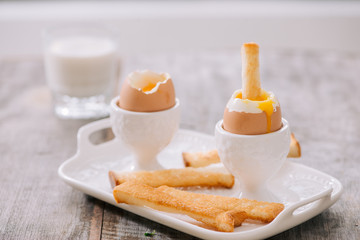 Fototapeta premium delicious breakfast with soft boiled eggs and crispy toasts, closeup