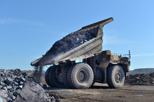 large mining loader unloads extracted ore or rock. View from the back