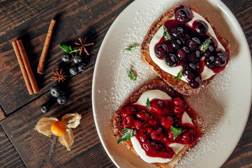 sweet toast with berry jam at dark wooden background