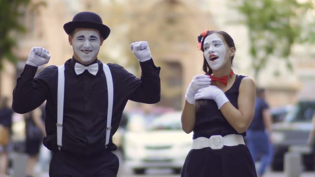 Friendly mime give his girlfriend a hot tea to warm her