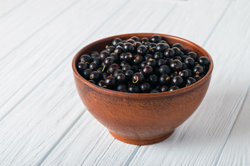 Black currant on wooden table with leaf sprig