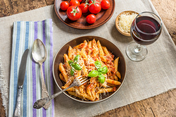 Pasta All'Arrabbiata - a traditional Italian dish with parmesan cheese and red wine on a rustic...