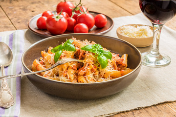 Pasta All'Arrabbiata - a traditional Italian dish with parmesan cheese and red wine on a rustic background
