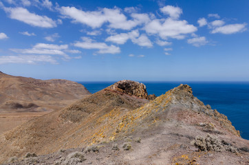 Typical landscape of Fuerteventura with barren volcanic mountains and the ocean - a view from the Entallada lighthouse terrace