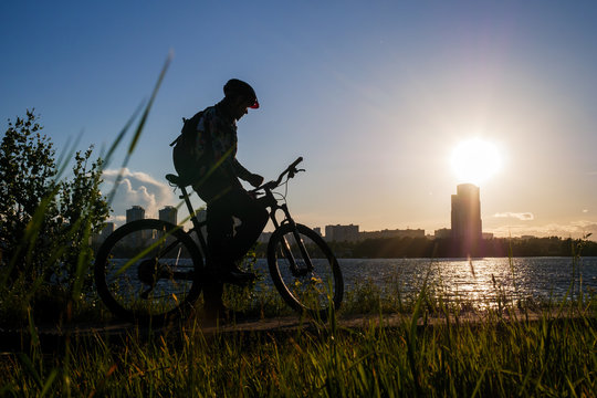 Photo of bicyclist wearing helmet riding around city in evening