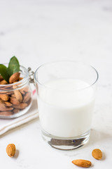 Obraz na płótnie Canvas Almond milk in a glass on a white background. Organic vegan milk