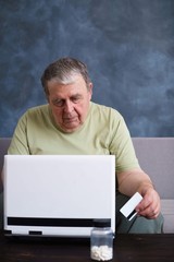 Old man browsing internet doing online shopping using credit card. Payment, banking, innovation technology and people concept.