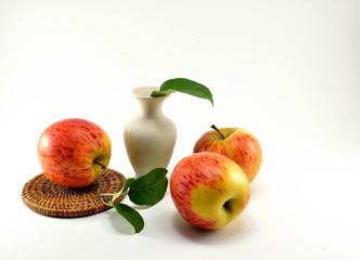 Three ripe red apples and a green twig.