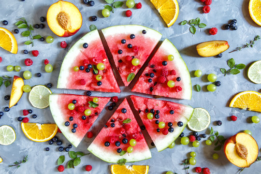 Bright summer wallpaper with watermelon slices, peaches, oranges and berries.