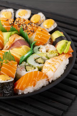 A set of sushi and rolls on a black background.