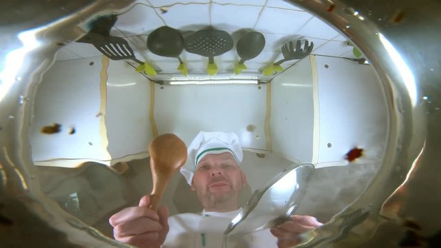 Chef throws pasta in a pot of boiling water, the view from the pan.
