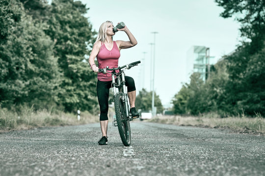 Frau mit Mountainbike im Wald unterwegs