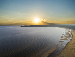 Aerial view of seashore with beach, lagoons and coral reefs. Coastline with sand and water. Tropical landscape. Aerial photography. Birdseye. Sea, beach, sky, clouds.