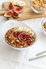 Peanut-butter banana, chocolate smoothie bowl decorated banana slice, fresh figs and nuts.