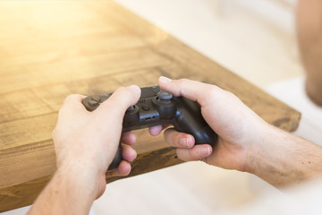 young man holding game controller playing video games