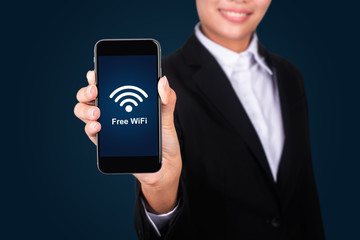 business and mobility communications concept: businessman holding a modern smartphone with free wifi zone icon.