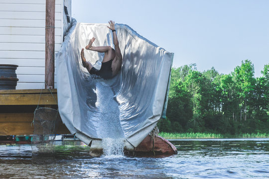 VILNIUS, LITHUANIA - JUNE 2018 - a joung man slides with a water wet roller coaster