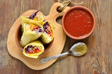 Tortilla wraps with vegetables and tomato sauce, top view