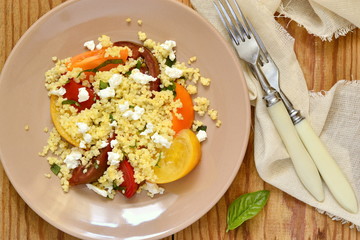 Millet with basil and fresh tomatoes and goat cheese, top view