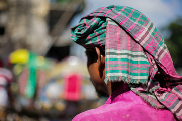 rickshaw puller in dhaka wearing colorful fabric on head for protection against heat