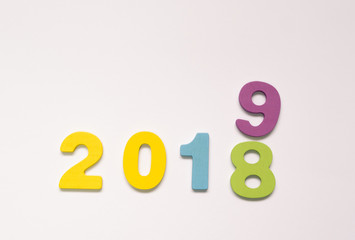 Colorful wooden numbers on white background. New year concept. Change the year 2018 to 2019.
