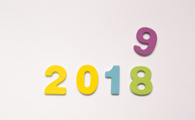 Colorful wooden numbers on white background. New year concept. Change the year 2018 to 2019.