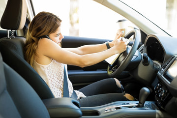 Woman multitasking while driving a car