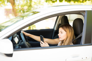 Fototapeta na wymiar Woman using phone while driving