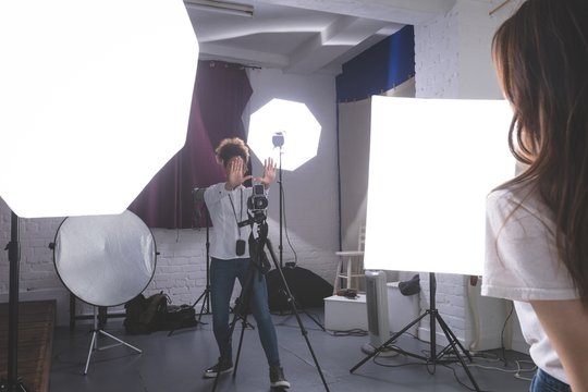 Female photographer clicking photos of model