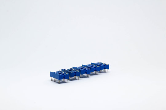 Row of five blue IC socket on white background.