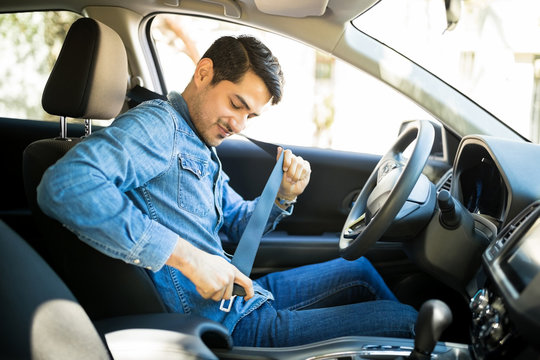 Man Fastening Seat Belt In The Car