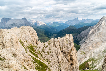 Panoramic view of a climber standing on the top of cliff in Dolomites Mountains. Italian Dolomites. Panoramic view of man walking on the ridge of the rocky mountains. 