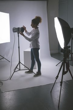 Female photographer adjusting strobe lights