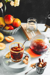 Apple cider drink, hot cocktail with cinnamon sticks and apple slices. Tea with spices. Autumn cozy mood