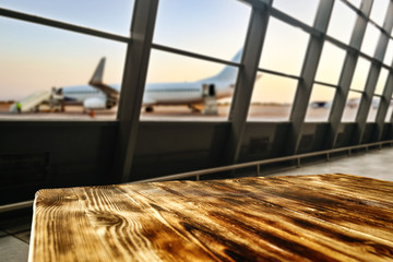 Wooden desk of free space and airport background with big window 