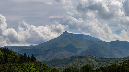 Cloudy autumn landscape on green mountains peak