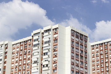 Horizontal shot of tall concrete mass housing building corner in Izmir at Turkey with blue sky background