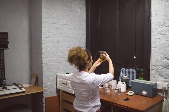 Female photographer checking a chemical in photo studio