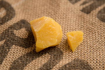 Pieces of natural bees wax on neutral jute background. Blocks of yellow wax.