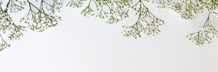 Minimalist white copy space with small flowers at the top