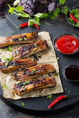 Roasted sliced barbecue pork ribs on  dark background Close up