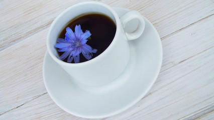 Delicious and healthy beverage from chicory, on wooden background.