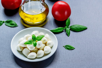 Mozzarella, red tomatoes and fresh Basil on a black background. top view. Flat lay. Food concept. Healthy and wholesome food