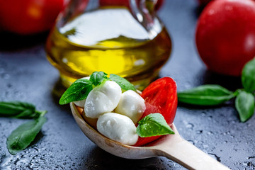 Mozzarella, red tomatoes and fresh Basil on a black background. top view. Flat lay. Food concept....